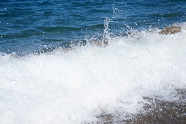 Foto ola del mar. costeros transparente mar / océano estrellarse ola con espuma