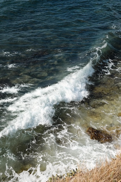 Ola de mar con espuma blanca. Foto vertical