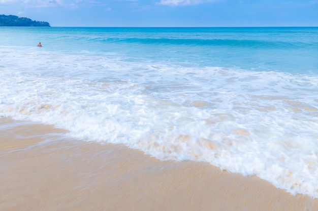 La ola del mar extiende espuma blanca en la playa