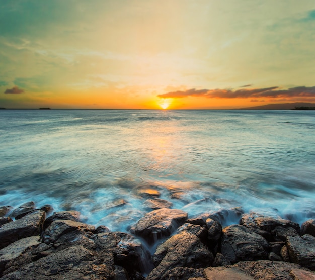 La ola del mar golpeó la roca al atardecer en Hawai