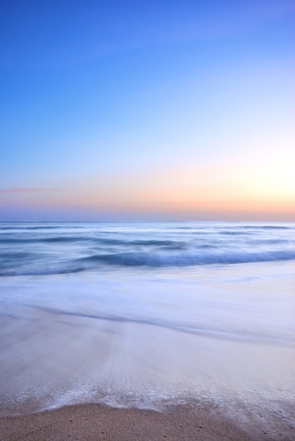 ola de mar en la playa al atardecer