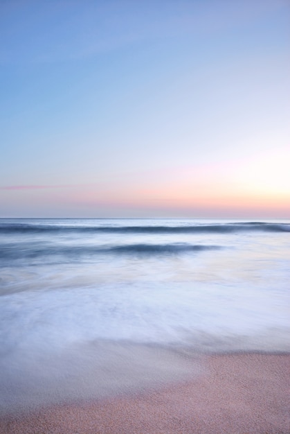 ola de mar en la playa al atardecer