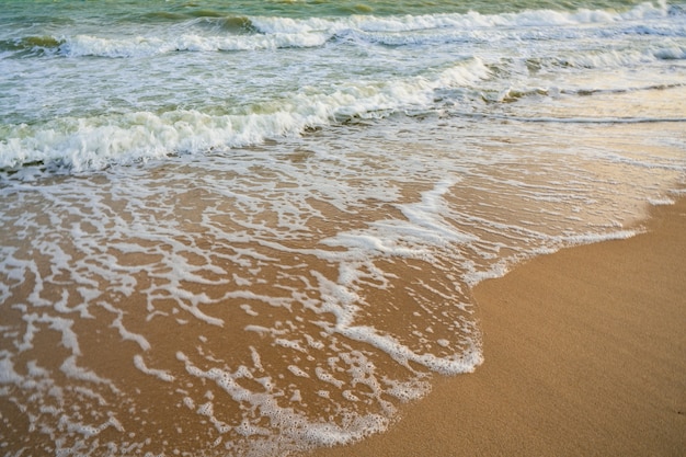 Foto ola del mar en la playa de arena