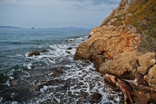 Ola de mar rompe en paisaje de rocas de playa