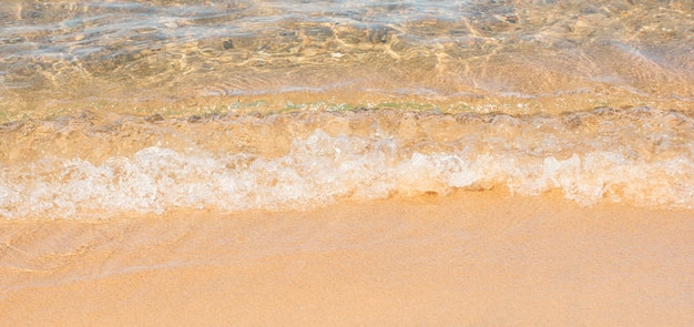 Ola de mar suave sobre fondo de verano de playa de arena