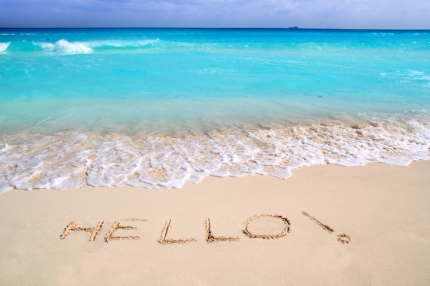 Olá mensagem feitiço escrito na areia da praia tropical