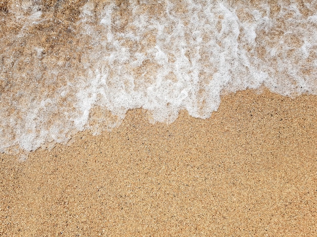 Foto ola oceánica en la playa de arena