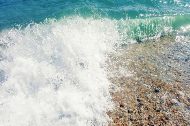 Ola de océano azul en la playa de arena cerca de fondo de verano