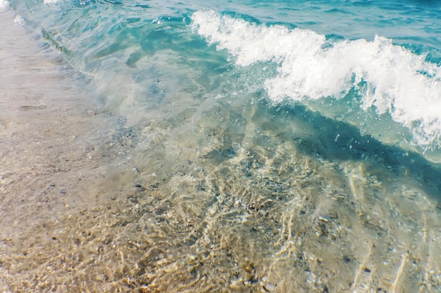 Ola de océano azul en la playa de arena Fondo de verano