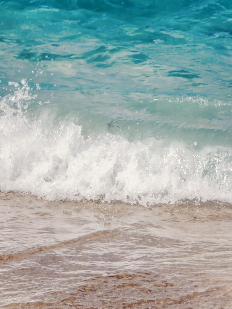 Ola de océano azul en la playa de arena Fondo de verano
