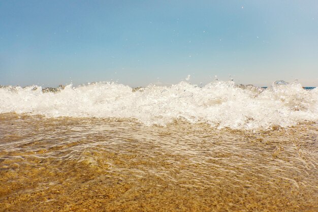 Ola de océano azul en la playa de arena Fondo de verano