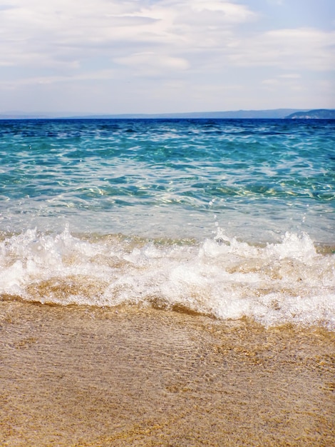 Ola de océano azul en la playa de arena Fondo de verano