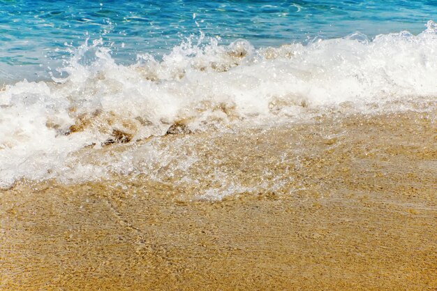 Ola de océano azul en la playa de arena Fondo de verano