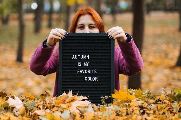 Foto olá outono garota de cabelo vermelho com carta quadro de mensagens com texto outono é a minha cor favorita