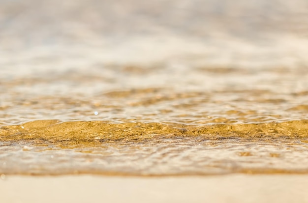 Ola que fluye en la playa de arena de mar Fondo de vacaciones de verano