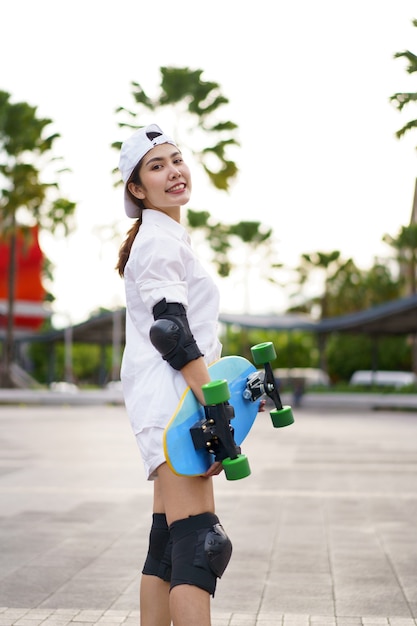 Olá summer surfers pessoas asiáticas se divertindo com pranchas de surf ou surf skate ao redor do fundo das ruas da cidade em um dia de verão. estilo de vida de relaxamento grátis e conceito de tendência milenar