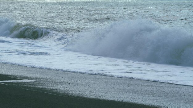 Ola de tormenta en el mar mar oscuro superficie del océano salpicaduras de agua de las olas rompiendo cámara lenta