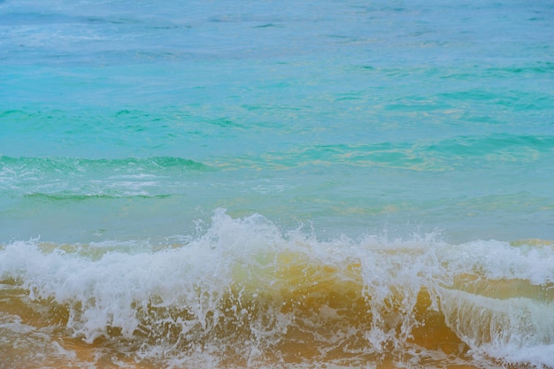 Olas azules del océano y arena amarilla de la playa.