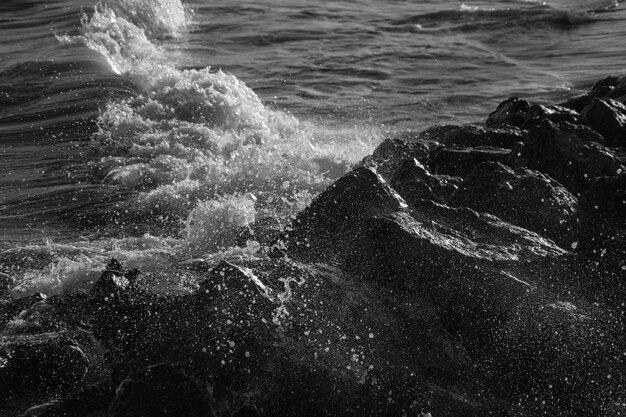 Foto olas chapoteando sobre las rocas