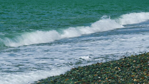 Las olas chocan con el agua azul del océano y las olas con el fondo marino de espuma blanca en tiempo real