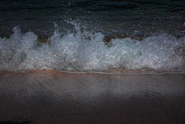 Foto olas y espuma de agua de mar con agua clara en una de las playas