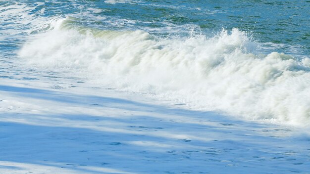 Las olas espuma y piedras de colores detalle del mar y la espuma de las olas en la playa de guijarros todavía