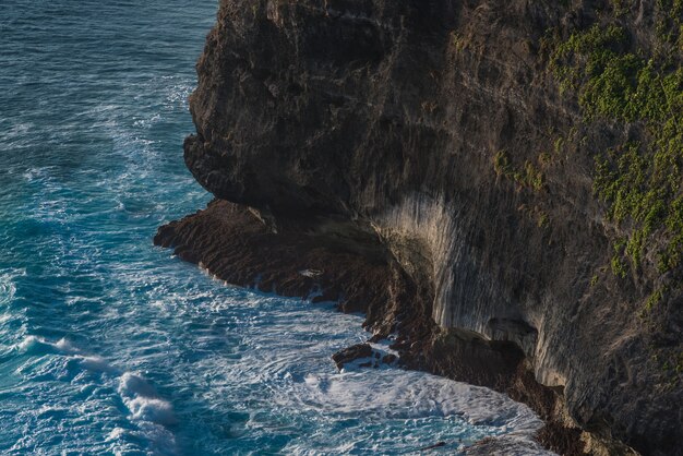 Las olas golpean la roca. Famoso templo de Uluwatu en Bali, Indonesia.