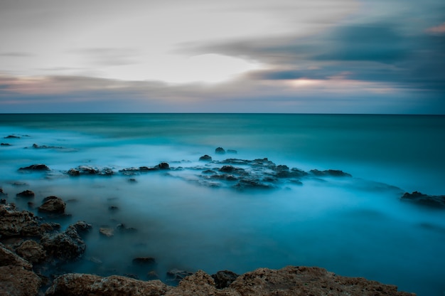 Foto las olas del mar chocan contra las rocas de la orilla.