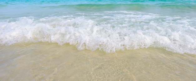 Las olas del mar golpean la playa de arena el mar es hermoso cristalino esmeraldaCerrar