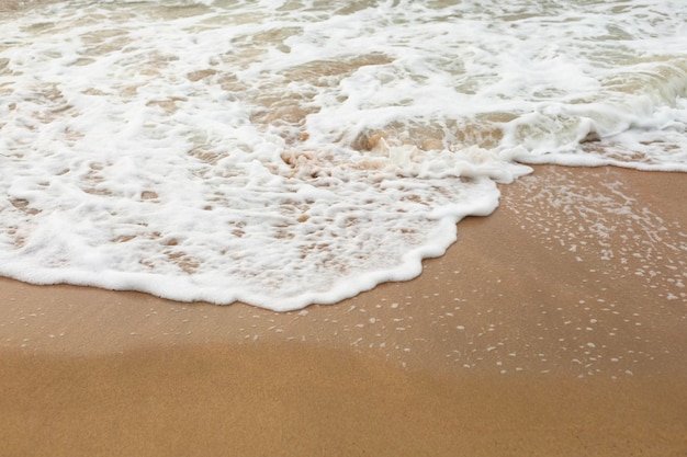 Las olas del mar en la playa de arena cierran el fondo