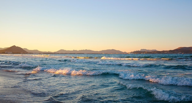 Olas del mar y puesta de sol en la playa de Can Picafort de Mallorca