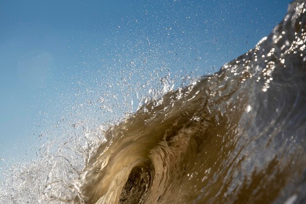 Foto las olas del mar salpicando la orilla contra el cielo despejado