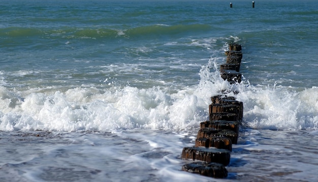 Las olas del mar se vuelven contra un rompeolas