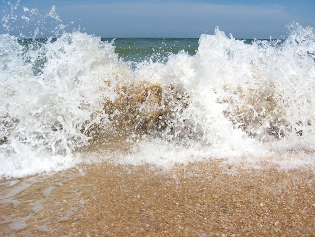 Olas marinas en la arena de la costa