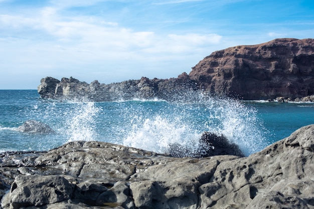 Las olas del Océano Atlántico están salpicando sobre la lava enfriada en la isla de Lanzarote, España.