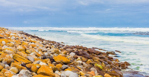 Olas del océano que llegan a la costa cubierta de rocas capturadas en Ciudad del Cabo, Sudáfrica