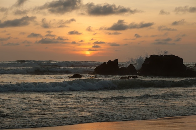 Olas en la playa al atardecer naranja