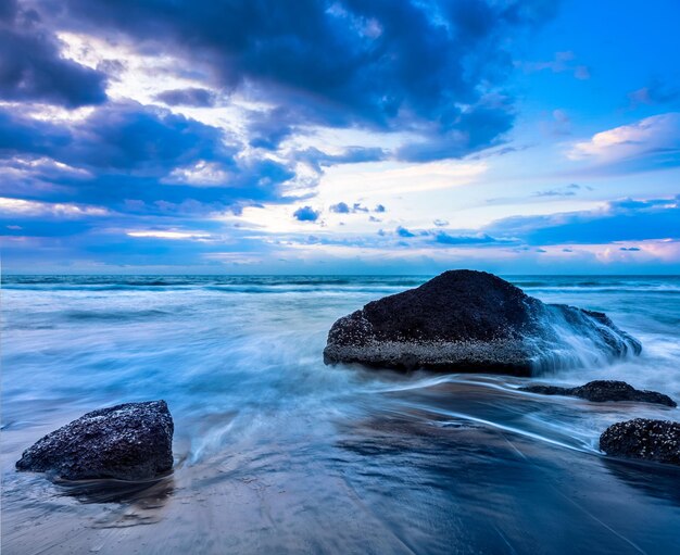 Olas y rocas en la playa del atardecer