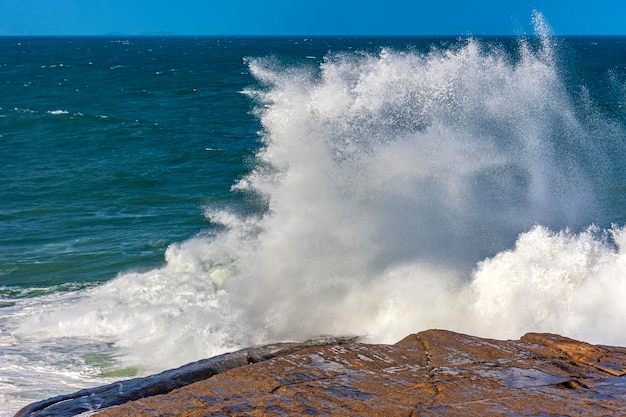 Las olas se rompen sobre las rocas con salpicaduras de agua