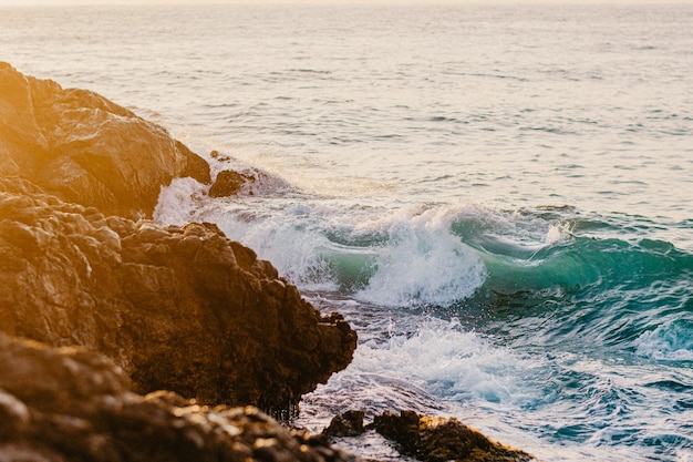 Foto olas rompiendo en las rocas durante el amanecer