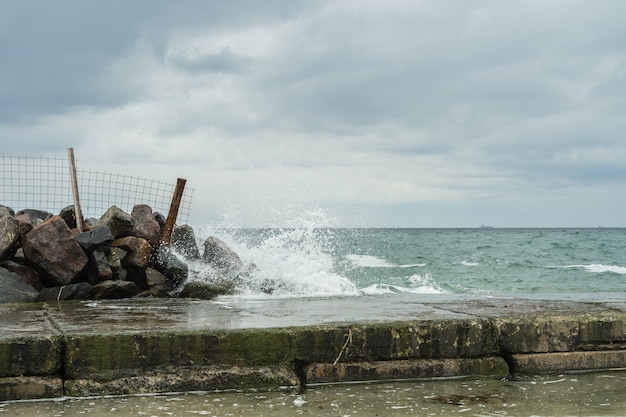 Olas rompiendo en las rocas cerca del muelle