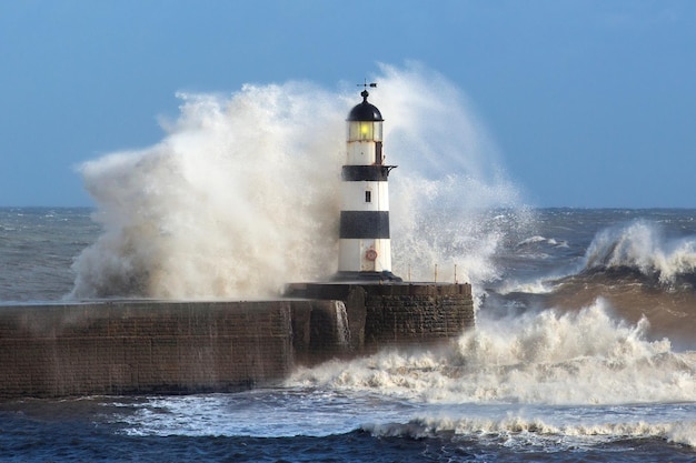 Olas rompiendo sobre el faro de Seaham