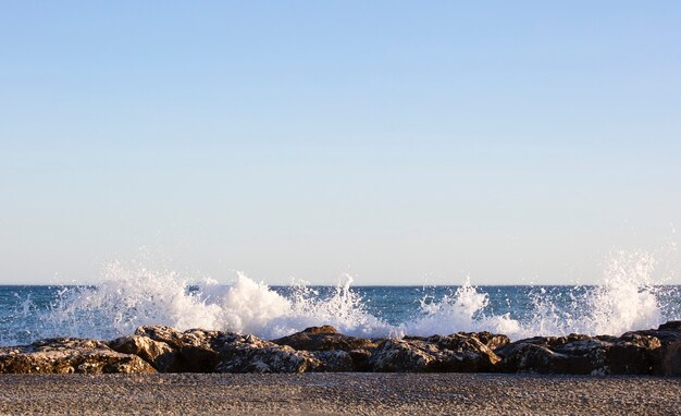 Las olas salpicaban las rocas en un día muy ventoso al atardecer