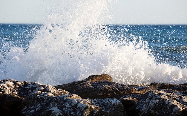 Las olas salpicaban las rocas en un día muy ventoso al atardecer