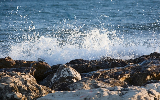 Las olas salpicaban las rocas en un día muy ventoso al atardecer