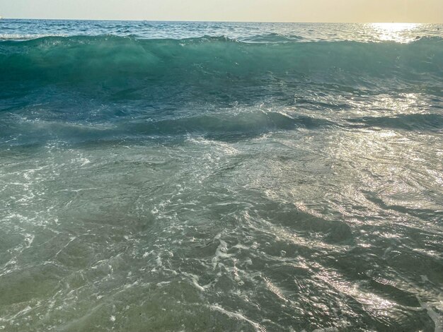 Olas salpicadas de agua en la playa en el mar de vacaciones en un turista cálido tropical oriental