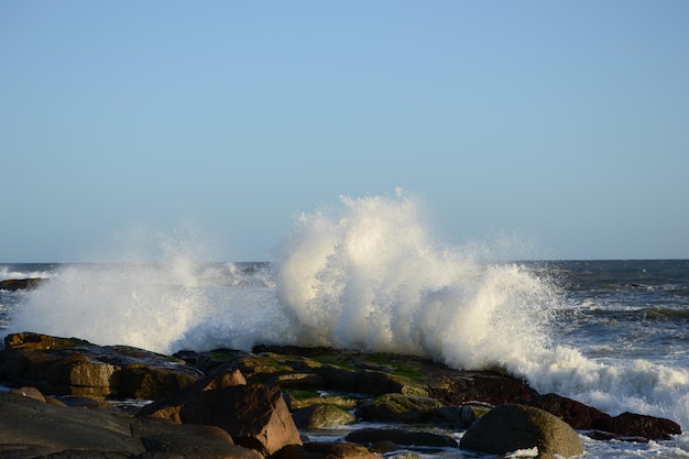 Foto las olas salpican en el mar contra un cielo despejado