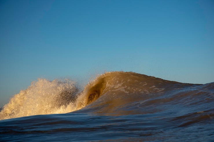 Foto las olas salpicando en el mar contra el cielo azul claro