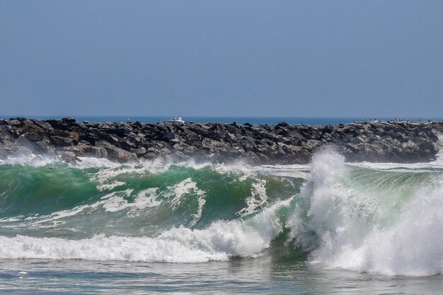 Foto las olas salpicando el mar contra el cielo despejado