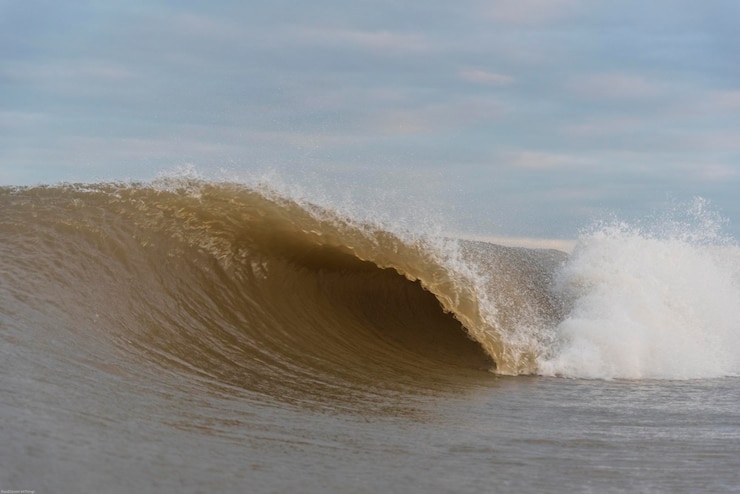 Foto las olas salpicando en la orilla contra el cielo